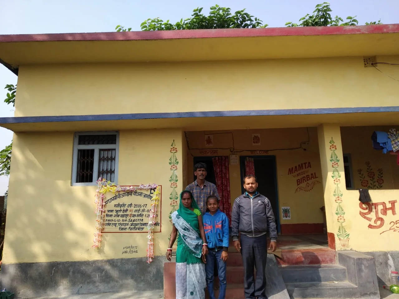 Beneficiary family outside completed rural house
